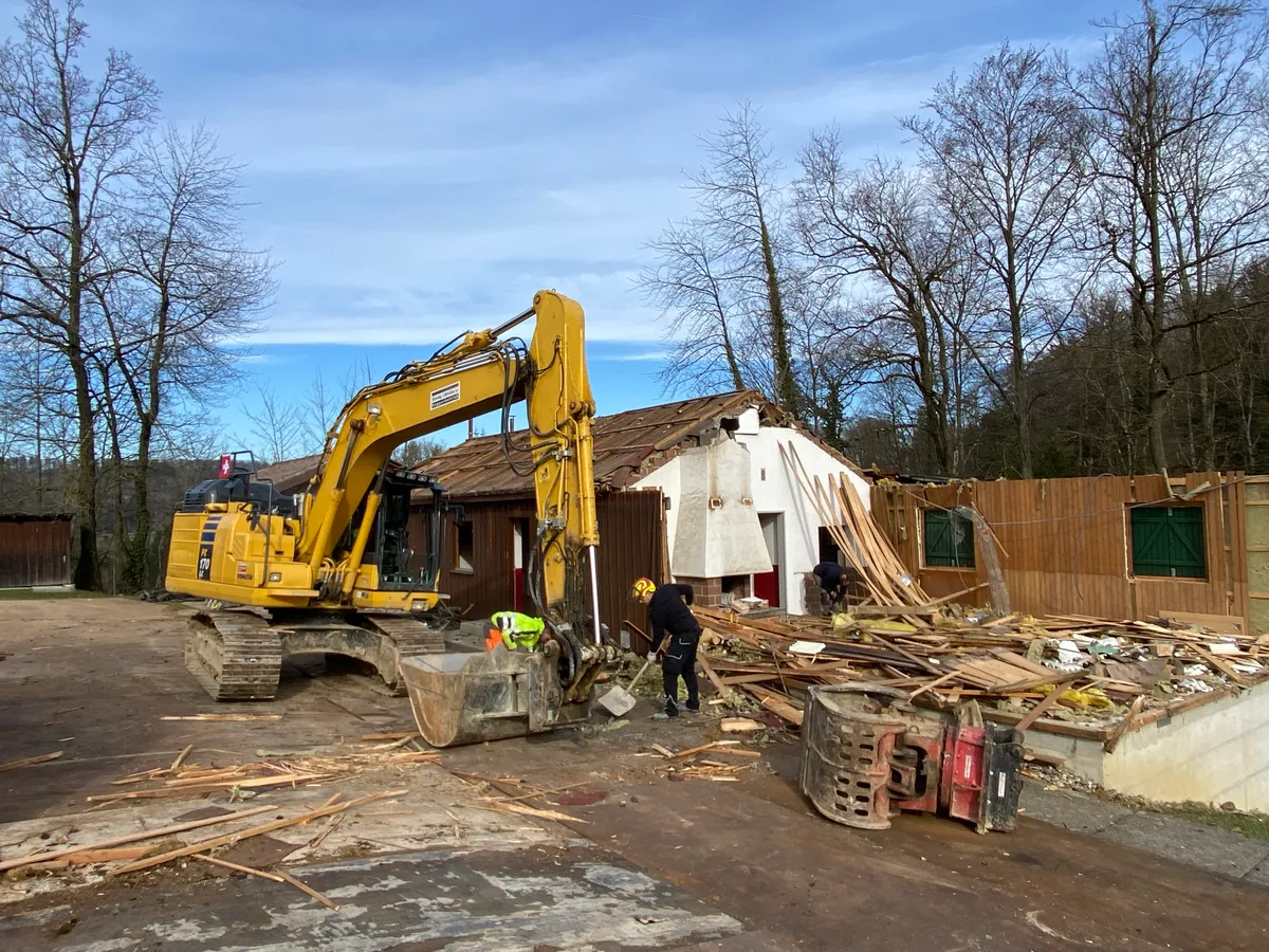 Ein Bagger arbeitet am Abbruch des Pfadiheims in Weisslingen.